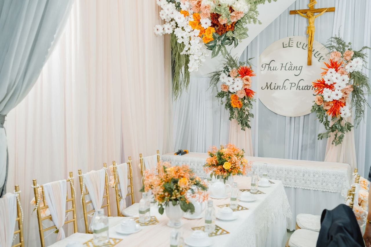 about-us Beautiful wedding decoration featuring floral arrangements and elegant table setup in a bright setting.